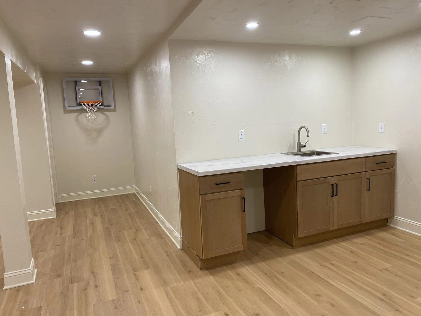 Wet bar in basement with fresh paint on walls, new LVP flooring install