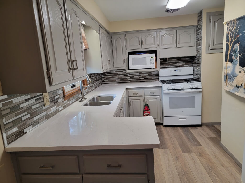 Newly painted kitchen cabinets, backsplash and flooring.